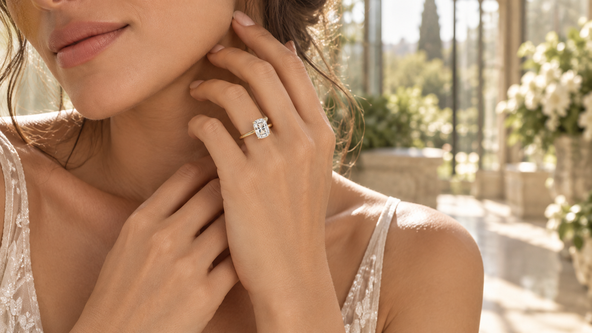 Elongated cushion solitaire on a plain yellow gold band in a sunlit conservatory