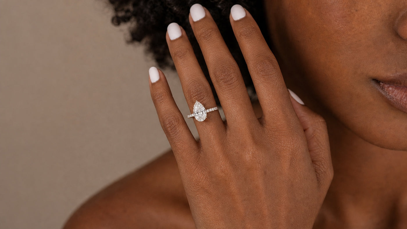 Close-up of the Pearlina pear diamond engagement ring on a Black woman