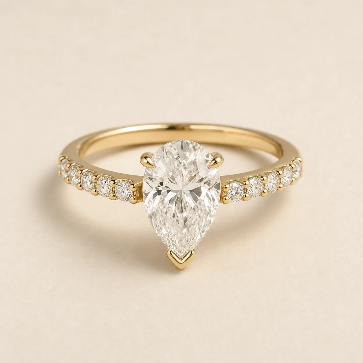 Pear lab-grown diamond engagement ring with a yellow-gold petite diamond band